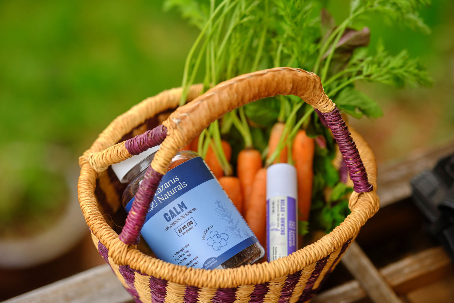 Lazarus Naturals Calm Gummies & Unwind Balm in a basket with carrots.